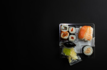 Sushi box kiku. Top view on black background
