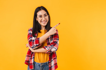 Photo of happy brunette woman smiling while pointing finger aside