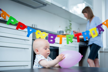 Happy mother with baby celebrating first birthday
