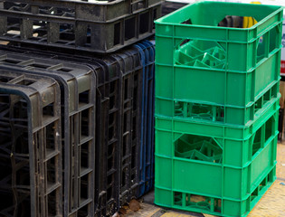 Storage with empty bottle crates. Ready to charge black and green crates for soda, beer or wine