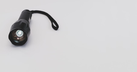 black aluminium body LED flashlight on a white surface