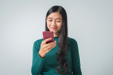 Shot of pretty young female holds modern smart phone amazed by unbelievable message winner, happy...