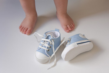 the first baby shoes on the background of the babies feet	