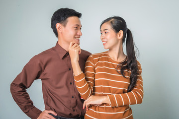 Young happy asian couple lover in brown shirt beautiful woman and thin man.
