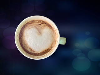 Cup with cappuccino with foam in the shape of a heart, on an abstract background. Porcelain mug of latte or americano coffee with milk.