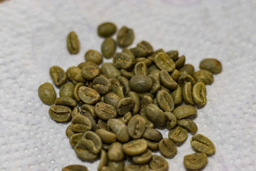 green coffee beans on white background close up