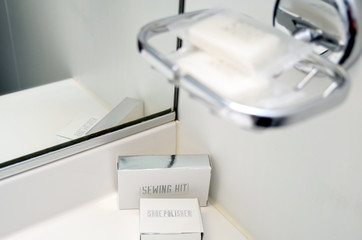 Bathroom amenities like hand soap, sewing kit or shower cap with towels in cabin or stateroom on...