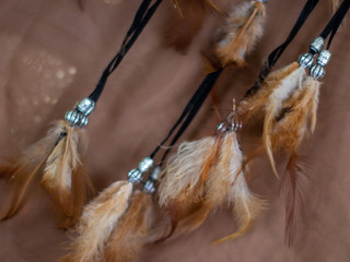 A lot of fluffy beige feathers on a dreamcatcher.
