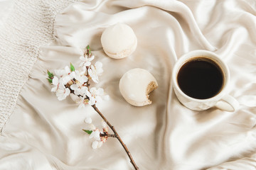 cup of coffee with marshmallows and flowers.beige silk background