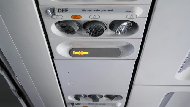 Seatbelt sign from on to off at the overhead pannel inside an airplane