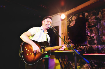 A nice Man playing guitar at a bar