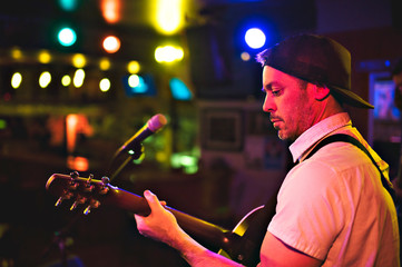 A nice Man playing guitar at a bar