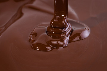 Melted chocolate swirl background. Liquid chocolate close-up
