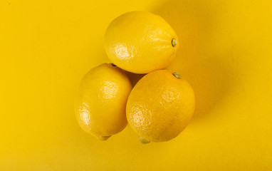 Yellow lemons isolated on a yellow background. closer view