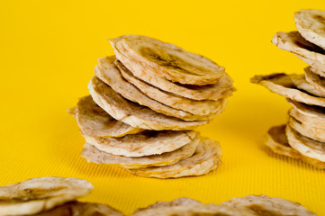 Dried banana chips, sliced in thin circles. Background for healthy and natural nutrition.