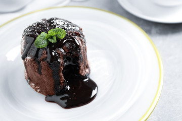 Delicious warm chocolate lava cake on plate, closeup