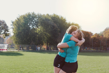 Young football players embracing each other