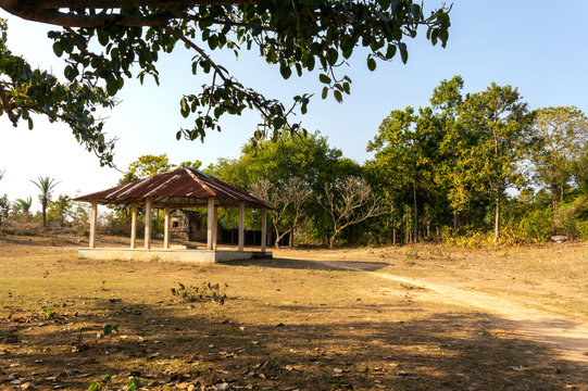 Open house with tin roof made of eight pillars for pray beside Sonamoni Pahar which is made by single big rock with green trees at West Bengal in India