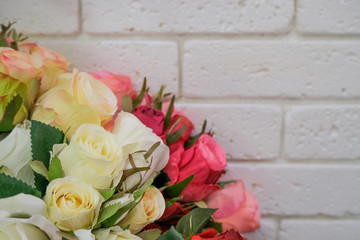 Artificial bouquet of flowers. Bouquet of mixed flowers in the stylish flower shop with white brick wall.
