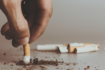 Hand extinguish cigarette.Cigarettes is addictive to be cancer.smoking reduction campaign in World...