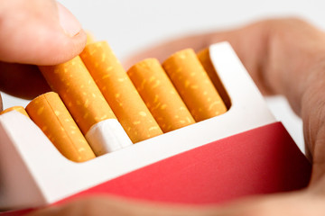 Hand pull out cigarette in pack.Cigarettes is addictive to be cancer.smoking reduction campaign in World No Tobacco Day.
