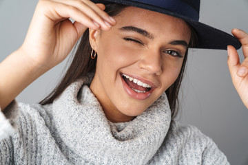 Image of nice happy woman in black hat smiling and winking at camera