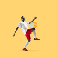 Fototapeta na wymiar Football player kicking scotch tape on yellow background. Copyspace for your proposal. Modern design. Contemporary artwork, collage. Concept of sport, office, hard work, dreams, business, action.