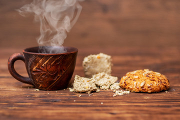 Cup of hot coffee, cookies and halvah on a wooden table_