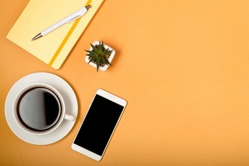 coffee, notebook and pen, phone on a beige background, minimalism concept