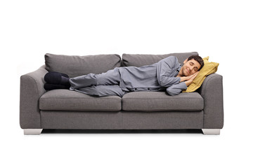 Man in pajamas sleeping on a sofa and dreaming a beautiful dream
