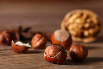 hazelnuts and walnuts with split shells on a wooden table close-up
