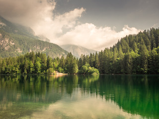 Photo of an alpine lake surrounded by mountains in summer