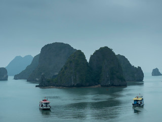 Fototapeta na wymiar Halong Bay with boats in fog, creating moody colors