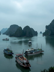 Halong Bay with boats in fog, creating moody colors