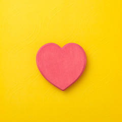 One wooden heart on yellow background. Hearts concept. Copy space.