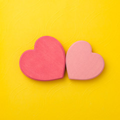 couple of wooden heart in love on yellow background. Hearts concept. Copy space.