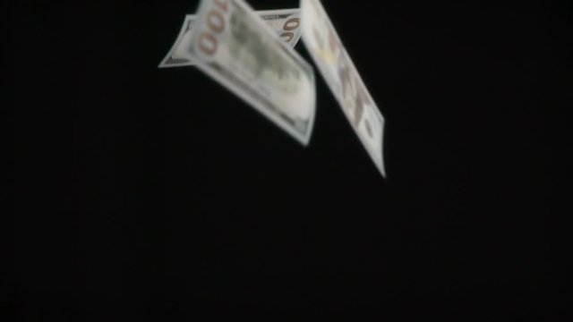 Banknotes in Flight. Monetary denominations of $ 100 in a large number of slowly falling down on black background. Filmed at a speed of 240fps