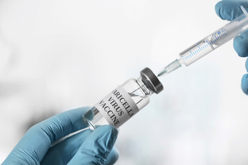 Doctor filling syringe with chickenpox vaccine indoors, closeup. Varicella virus prevention