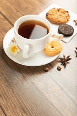 A cup of tea with cocoa and butter cookies