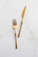 golden fork and knife on a white serving table