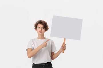 Concerned female protester holding empty signboard with copy space.