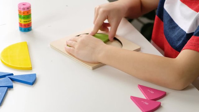Child hand doing simple math exercises with fractions on white table, close up. dividing fractions