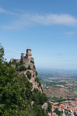 Fototapeta na wymiar The fortress, first tower, at the foot of the mountain city. Summer sunny day. Pass of the witches. vertical photo Fortification on top of the mountain, old castle. Vertical photo. San Marino, Italy