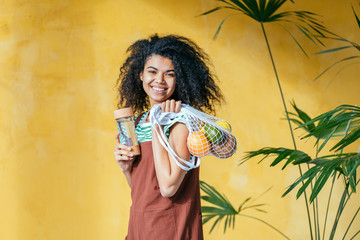 Female hands hold eco bag of vegetables, greens and reusable water bottle. Zero waste. Sustainable lifestyle concept.