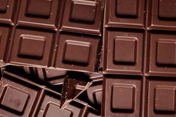 Dark chocolate pieces isolated on white background. Top view.