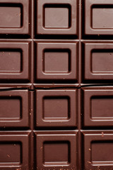 Dark chocolate pieces isolated on white background. Top view.