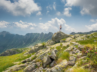 Fototapeta premium man standing on a stone in the Dolomites with high mountains in the background