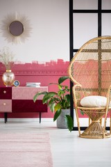 Stylish wicker peacock chair in trendy living room interior