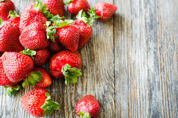 Fresh ripe strawberries on a wooden background. Organic juicy berries.