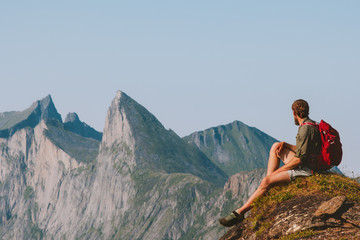 Man relaxing in mountains enjoying view adventure travel vacations outdoor traveler sitting on cliff healthy lifestyle trekking in Norway